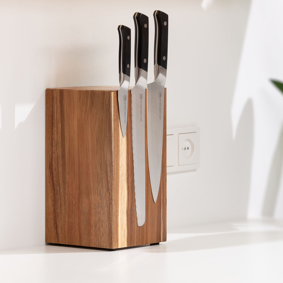 Wooden magnetic knife block holding three knives