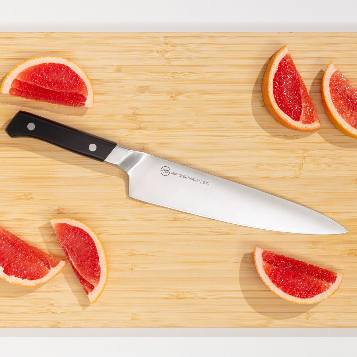 Koksmes op een bamboe snijplank met partjes grapefruit